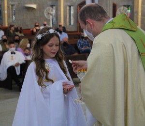 Crianças recebem o sacramento da Primeira Comunhão